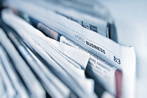 Folded newspapers with the world business page title showing